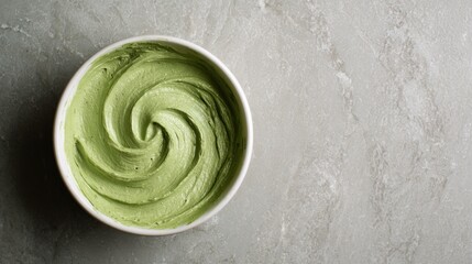 Green matcha swirl in white bowl on stone