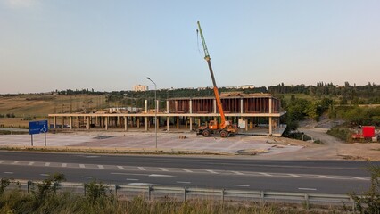 Construction Site Featuring a Crane Operating Efficiently Beneath a Clear Blue Sky