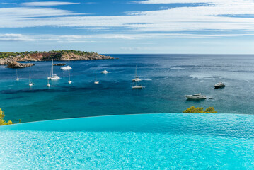 Infinity pool overlooking the Mediterranean sea in Ibiza with yachts and sailboats