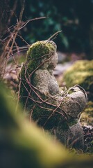 Stone figure overgrown with moss and vines.