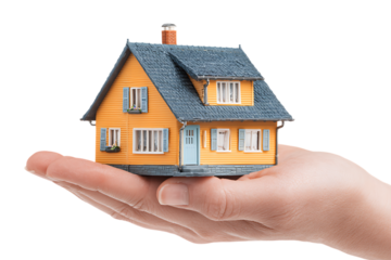 Hand holding a small model house.