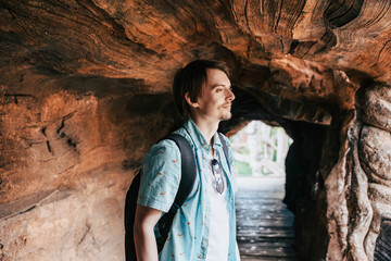 Man With Backpack Standing in Massive Hollow Tree Tunnel