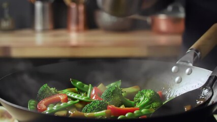 Close-up of Stir-Frying Fresh Vegetables with Sauce in a Wok: Cooking Broccoli, Peas, and Red Pepper in a Hot Pan for a Healthy Meal Preparation - Powered by Adobe