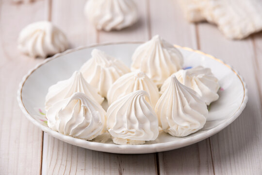 Fresh homemade meringue cookies over wooden table