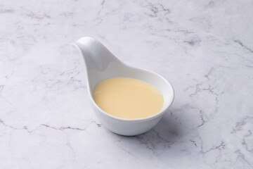 Condensed milk in a bowl over marble table