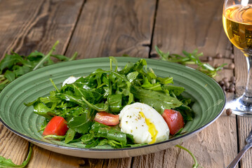salad with greens, tomatoes and poached egg in a green plate