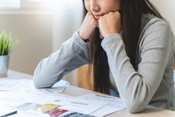 stressed young asian woman trying to find money to pay credit card debt.