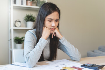 stressed young asian woman trying to find money to pay credit card debt.