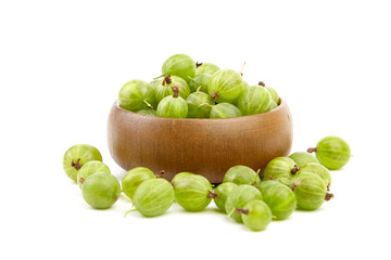 Fresh green gooseberries in a wooden bowl, surrounded by scattered berries, showcasing vibrant colors and natural textures, perfect for culinary use or healthy snacking inspiration