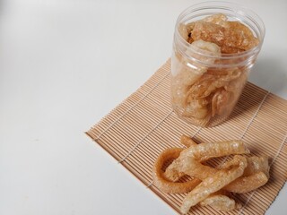Kerupuk kulit sapi or rambak or beef skin crackers in plastic jar isolated on white background....