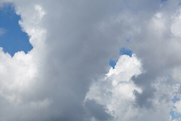 Dramatic cloud formations with varying shades of gray and white against a bright blue sky, creating a captivating atmosphere of nature's beauty and tranquility