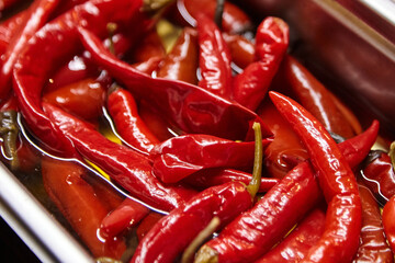 Fresh red chili peppers submerged in olive oil, showcasing vibrant colors and textures, ideal for culinary presentations and spicy dishes, enhancing flavor and visual appeal