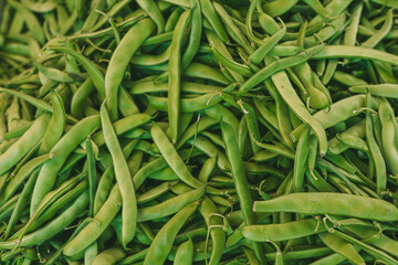 Fresh green beans piled together, showcasing their vibrant color and organic quality. Ideal for local markets and healthy eating concepts.