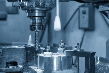 The hole drilling process the brass material parts on milling machine by flat drill tool in the...