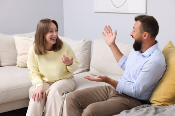 Friends laughing on sofa at home. Positive emotion