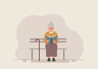 Elderly woman reading a book while sitting on a bench indoors  