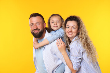 Portrait of happy family on yellow background