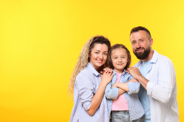 Portrait of happy family on yellow background. Space for text