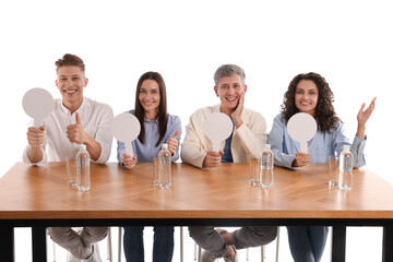 Panel of judges with blank score signs at table on white background