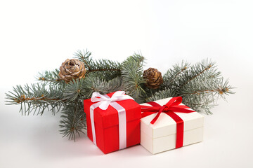 Two gifts, spruce branches and cones on a white background