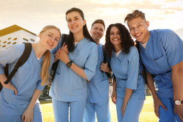 Group of medical students in uniforms with backpacks outdoors, low angle view