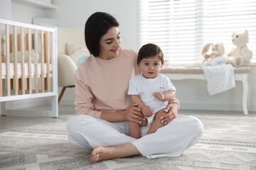 Happy mother with her cute little baby at home