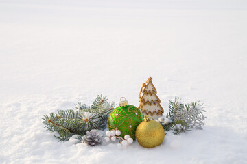 Christmas decorations and fir branches in fluffy snow. Copy space