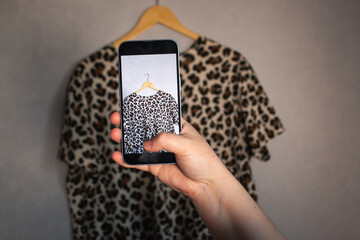 Woman taking photo of her old clothes for resale. Second hand concept. Closet organization.