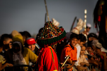 Fototapeta premium The Colorful Hat of the Moroccan Performer زي تقليدي مغربي فريد وسط الجمهور
