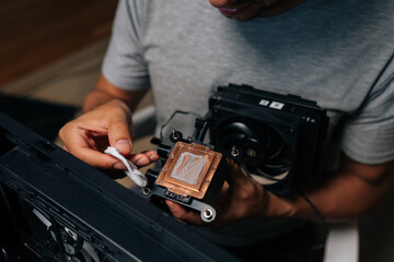 Close-up top view of precise computer maintenance involving cleaning processor cooling system,...