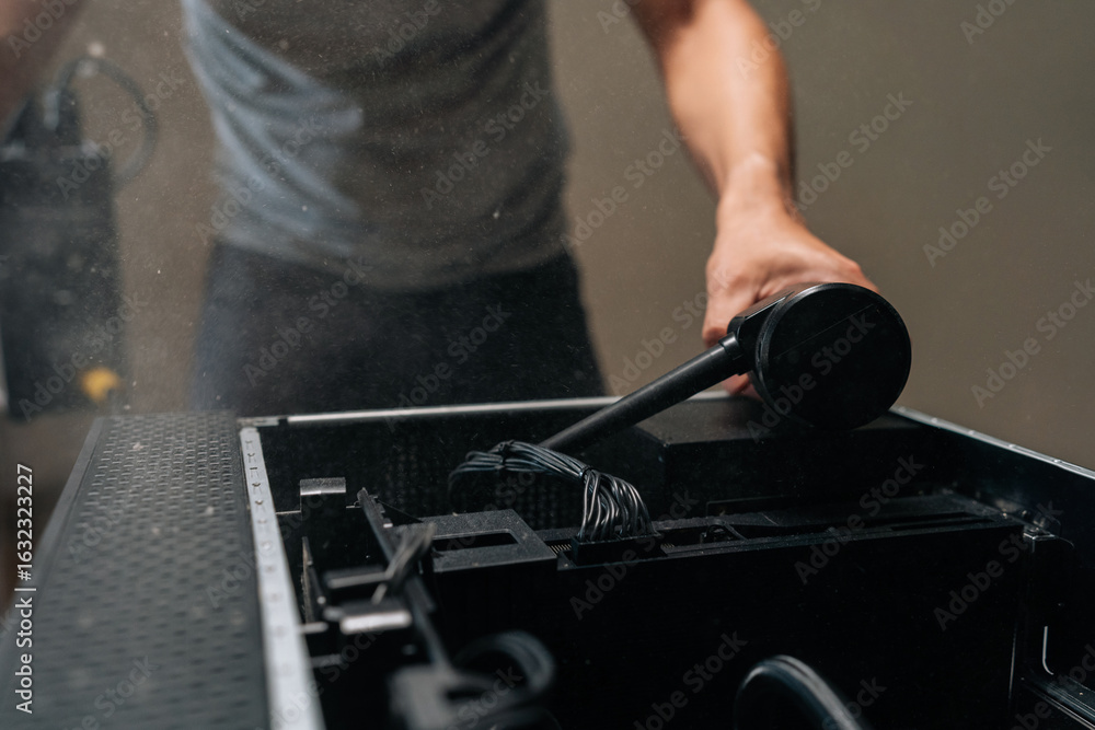 Poster detail cropped shot of computer technician cleaning desktop computer interior with air blower, maint