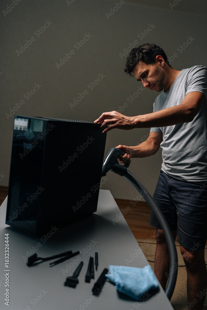 Poster vertical shot of computer technician using vacuum cleaner to clean inside of desktop computer case, 