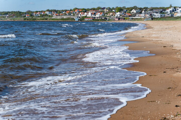 A stunningly beach scene featuring gentle waves gently lapping at the sandy shore beneath a clear...