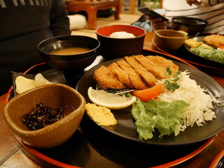 Delicious plated Japanese meal featuring breaded meat, rice, vegetables, and condiments display