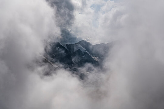 Mountains shrouded in thick clouds, with peaks barely visible. Mantova refuge al Vioz, Peio, Trentino.