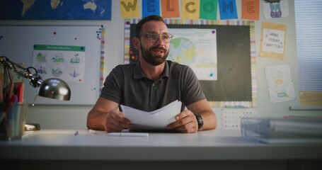 Male Teacher Giving School Test Results of Elementary School Student to His Mother. Teacher...