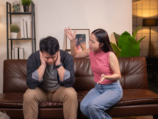 Asian wife complains and blaming to her husband on the living room sofa