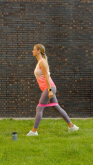 Woman exercising with resistance band on green lawn