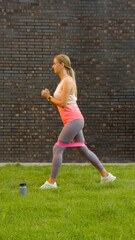 Woman exercising with resistance band on green lawn