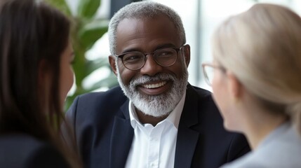 Smiling mature businessman engaging in a collaborative discussion with colleagues
