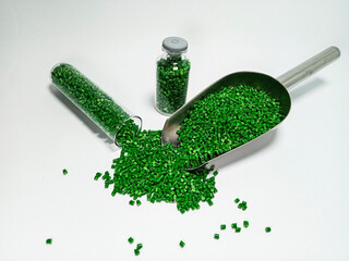 Green polymer masterbatch gradation, green pigment resin pellets in glass tubes poured on a white...