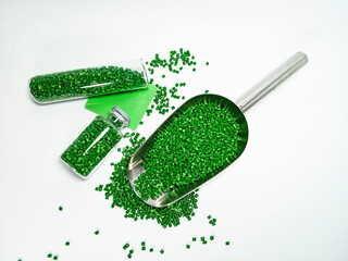 Green polymer masterbatch gradation, green pigment resin pellets in glass tubes poured on a white...