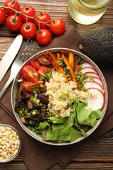 Healthy vegetarian food. Delicious Buddha bowl and ingredients on wooden table, flat lay