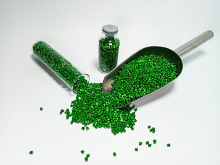 Green polymer masterbatch gradation, green pigment resin pellets in glass tubes poured on a white...
