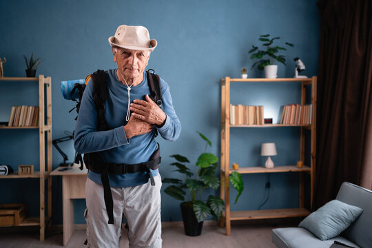 Retired traveler with backpack hold hands on heart chest feel grateful at home. Tourist makes active healthy lifestyle. Hiking, travel and trip - Powered by Adobe