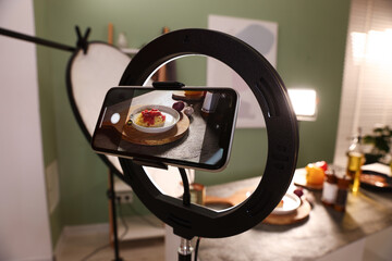 Shooting tasty pasta and ingredients with smartphone in studio, selective focus. Professional food photography