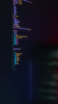 Programmer monitor source code interface with colorful syntax highlighting in dark theme. Captured at an angle with visible JavaScript or TypeScript structure. Ideal for illustrating modern software d