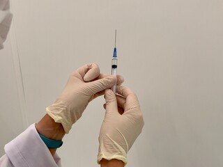 A medical officer in a white coat holds a syringe. Vaccination. High quality photo