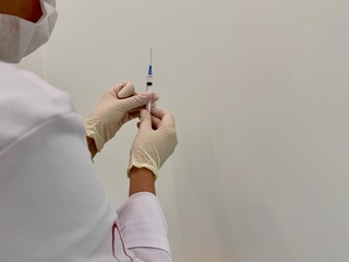 A medical officer in a white coat holds a syringe. Vaccination. High quality photo
