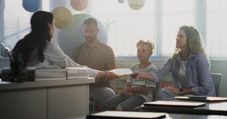 Mother and Father Looking at School Test Grades of Their Son During Parents Evening. Teacher and Parents Happy About Excellent Academic Performance and Behavior of Elementary School Boy. Medium Shot. - Powered by Adobe